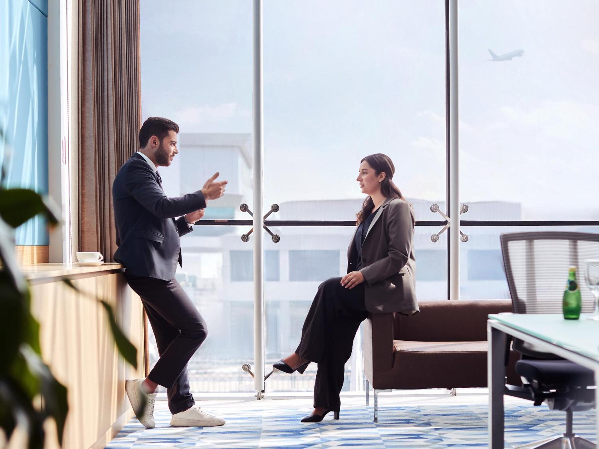Flora Inn Hotel Dubai Airport Exterior foto Two businesspeople talking in a meeting